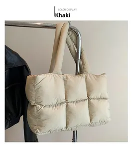 Detailed view of the khaki quilted puffer tote bag on a hanger with a stylish leather jacket