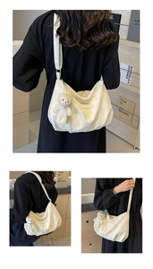 Detail einer weißen Hobo-Tasche mit Faltenoptik und einem süßen Plüschbär-Anhänger