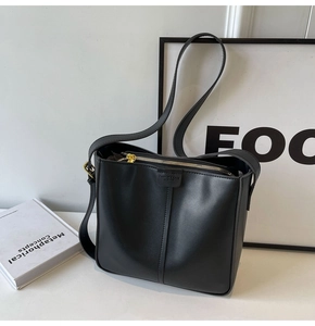 Detail view of black matte leather shoulder bag with golden zipper and fashion logo