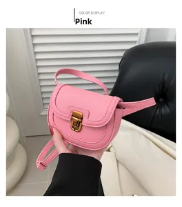 Pink mini saddle bag in lychee pattern leather with vintage gold clasp close-up