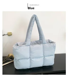 Close-up of light blue quilted puffer tote bag with glossy nylon finish and soft texture