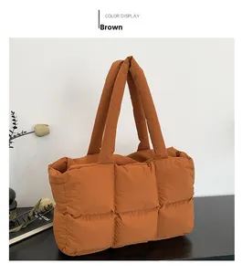 Detailed close-up of brown quilted nylon puffer tote bag with stitched square texture