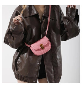 Pink lychee grain leather mini saddle bag with vintage gold buckle shown on model
