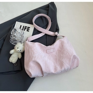 Pink fabric tote bag featuring a white plush bear keychain and adjustable shoulder strap
