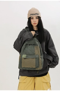 Detail view of water-washed canvas backpack with vintage color-blocking and durable front pocket