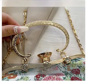 Close-up of the vintage floral embroidery and ornate golden metal handle with crystal inlay