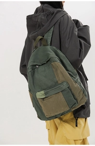 Detailed back view of a canvas backpack in army green and olive green patchwork design