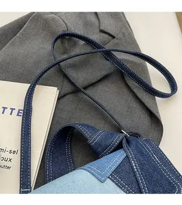 Close-up of contrast denim stitching and blue patchwork on a stylish crossbody bag