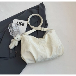 Detail view of cream white tote bag with marble texture and cute white bear keychain