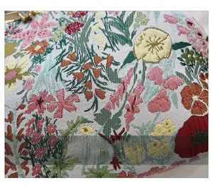 Close-up of vibrant jacquard embroidery and floral fabric with gold metal clasp detail