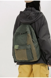 Outdoor green color-block canvas backpack shown on model for size and scale