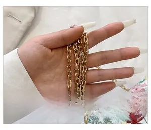 Close-up of golden metal chain strap on a bag with intricate floral embroidery details