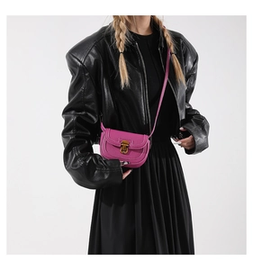 Detail of rose red saddle bag showing lychee grain leather and golden buckle clasp
