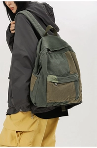 Side view of olive green patchwork canvas backpack with zipper pockets on female model