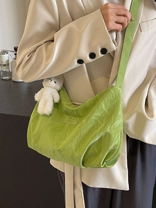 Green pleated tote bag with plush bear charm and adjustable wide shoulder strap