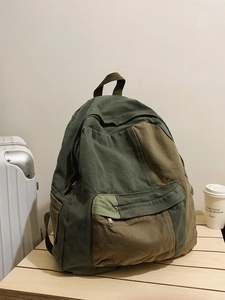 Neutral canvas backpack in olive green and dark brown with multi-pocket design