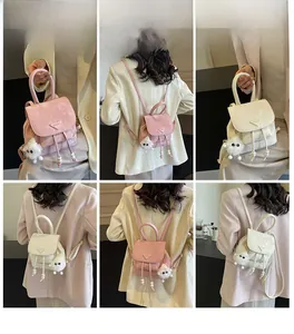 Detail shots of mini faux leather backpack with plush ball charm and drawstring closure