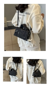 Detailed view of stitching on denim crossbody bag with cute white plush bear keychain