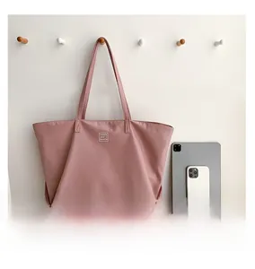 Pink waterproof nylon tote bag showing large capacity for tablet and phone