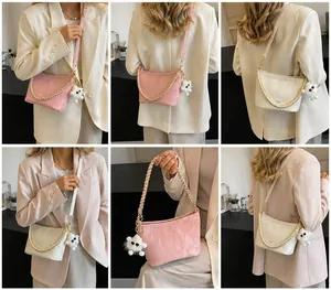 Detailweergave van de roze en beige emmertas met geplooide textuur en parelketting