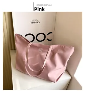 Close-up of pink waterproof nylon tote bag showing double straps and fashion logo patch