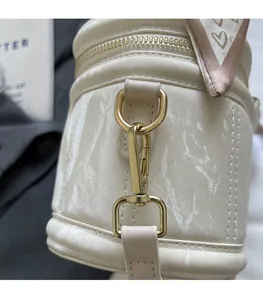 Detail van leren handtas met golvende textuur, gouden hardware en zijden sjaal decor