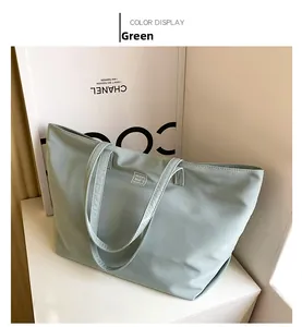 Detail of light green nylon tote bag featuring water-resistant fabric and brand label