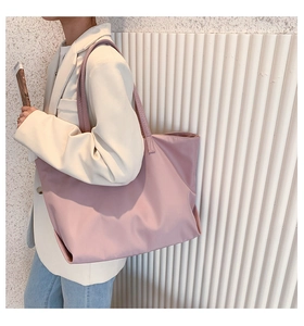Pink waterproof nylon tote bag shown in a professional business casual commute setting