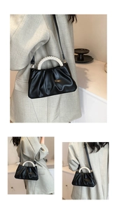 Detail of black cloud bag featuring pleated texture and white pearl bead handle with gold hardware