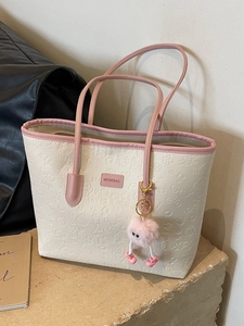Large beige tote bag with pink leather straps and embossed cartoon patterns