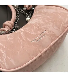 Close-up of pink marble pattern handbag with silver chains and heart charms