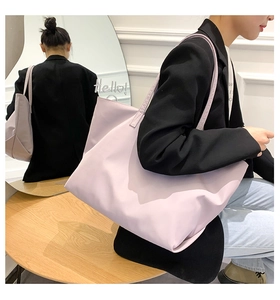 Detail of light purple waterproof nylon tote bag showing spacious capacity and shoulder strap
