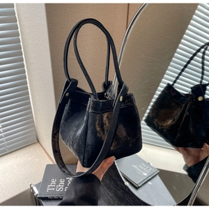 Détails d'un sac seau vintage noir avec des rivets métalliques et une bandoulière