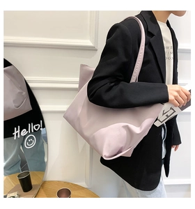 Detail view of lightweight light purple canvas tote bag worn by a model in a modern room