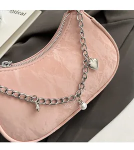 Detail of pink hobo bag with cloud texture, silver chain and heart star charms