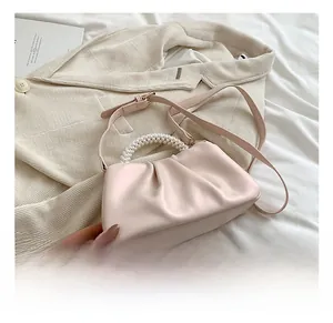 Pink cloud bag with elegant pearl handle and soft pleated details for versatile styling