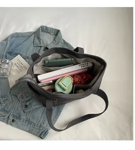 Detail view of large dark grey canvas tote bag interior showing multi-compartment storage space