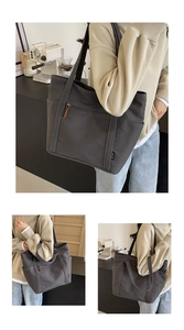 Detail of grey canvas tote bag with front zipper pocket and brown leather puller