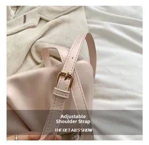 Detail showing the adjustable pink leather shoulder strap with a gold metal buckle