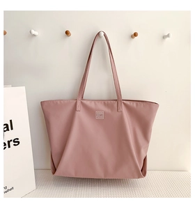 Detailed close-up of pink nylon tote bag showing soft texture and modern logo