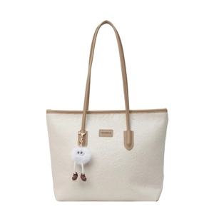 Fashionable beige tote bag with cartoon embossed patterns and cute plush monster charm