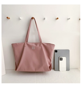 Close-up of waterproof nylon tote bag with logo detail and spacious interior for iPad