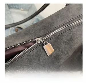 Macro shot of smooth silver metal zipper and grey suede fabric on a tote bag detail