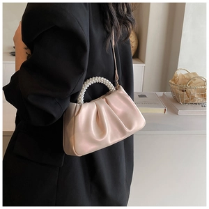 Detail of soft pearl handle and pleated texture on light pink cloud shoulder bag