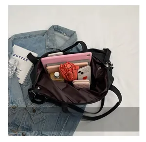 Top view showing large capacity interior of black tote bag with tablet, umbrella, and daily items