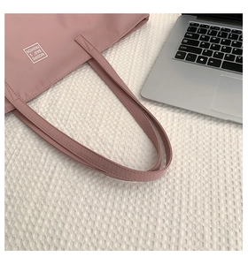 Detailed close-up of a pink nylon tote bag with MODIFEI BAG'S FASHION lettering