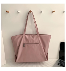 Rear view of a pink nylon tote bag showing the zipper pocket and sturdy shoulder straps