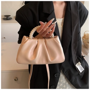 Detail of pink cloud bag with ruched leather and elegant pearl beaded handle