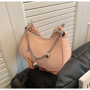 Detail of pale pink pleated underarm bag with silver star and pearl chain charms