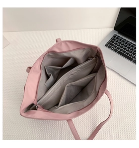 Detail view of pink nylon tote bag interior showing multi-compartment storage and gray lining